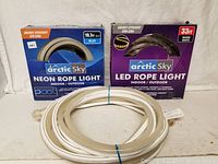 Photo showing two boxed Arctic Sky LED rope light products and one white LED rope light coil laid out in front