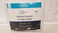 Photo showing Mainstays waterproof mattress protector packaging with size and features