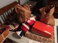 View of Santa figurine, pine cone wreath, assorted boxes with Christmas decor.