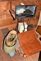 Cornwall oven broiler, Starrett wooden boxes, Detecto scale, vintage lamp, metal stand visible on wooden floor and wall background.