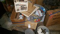 Overall lot showing air compressor box, galvanized wash bin, assorted boxes with hardware and tools