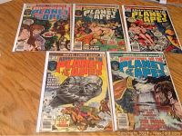 Five comic books from the series 'Adventure on the Planet of the Apes' laid out on a flat surface showing covers of issues 7, 8, 9, 10, and 11 with various ape and human characters.