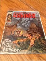 Comic book titled Sub-Mariner #16 on wooden surface, full front cover visible.