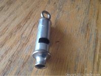 Close-up of vintage Acme whistle from side showing shape and mouthpiece