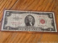 Front side of 1953 $2 U.S. Note showing Thomas Jefferson portrait and red seal. The note is worn with visible creases and folds.