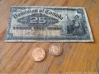 Photo showing all three items: the 1900 Dominion of Canada 25 cents Shin Plaster note, the 1919 3 cent silver coin, and the 1942 Canadian silver dime coin, on a wooden surface.