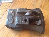 Top-side view of the cast metal axe head showing maker's name, patent number, and slot for handle mount.