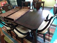 Full view of dining table with leaves installed and six chairs arranged around it