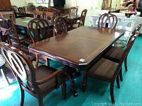 Full set view: rectangular table and six matching chairs on showroom floor