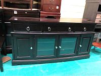 Front view of Broyhill TV stand showing four drawers with metal ring handles and four lower cabinets including two glass doors.