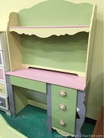 Full front view of child's desk with hutch showing pastel colors and flower knob details.