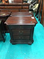 Pair of dark mahogany wooden nightstands seen from front and top, showing shaped edges on the tabletops and visible marks on finish.