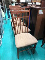 View of 4 Shermag wooden dining chairs arranged in a row showing side and front views, highlighting slat back design and beige upholstered seats.