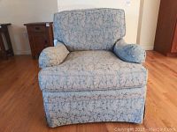 Front view of upholstered armchair with floral pattern fabric