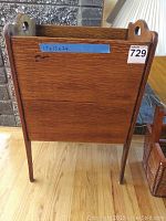 Photo showing the larger wooden magazine rack with dimensions labeled on blue tape: 17 inches high, 13 inches wide, 26 inches deep.