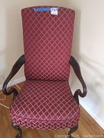 Front view showing the tall back with red diamond pattern upholstery and curved wooden armrests and legs.