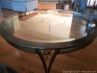 Top view showing clear oval glass top with metal frame.