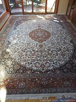 Full view of the large Karastan area rug in a sunlit room, showing overall condition and pattern.