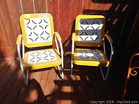 Two yellow and white metal chairs front facing on wood deck