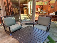 Two rocking chairs shown with metal table in background for overview
