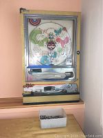 Full front view of pachinko machine on tabletop showing overall condition