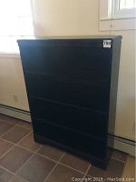 Wood bookshelf from front, showing closed shelves with no items inside.