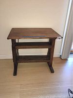 Front view of the vintage cheese press table showing cutting board top and sturdy wooden legs.