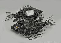 Pair of metal fish wall art sculptures shown together to depict the lot contents.