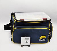 Side view of navy blue Plano branded tackle bag with yellow piping, a front zippered pocket and an adjustable shoulder strap.