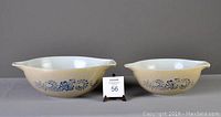 Two Pyrex Cinderella style nesting bowls in sand color with blue Homestead pattern, showing overall size and shape.