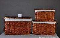 Three wicker baskets nested, showing the full set with fabric liners and leather handles