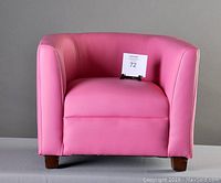 Front view of a child-sized armchair upholstered in bright pink vinyl, showing the seat, arms, and backrest with small dark brown wooden legs.