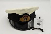 Full view of the vintage naval cap showing white top, black band, and detailed front insignia with crown and anchor.