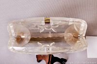 Top view showing the inside hinge and metal clasp of the clear Lucite clutch purse.