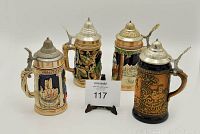 Set of four German-style lidded beer steins in various colors and designs