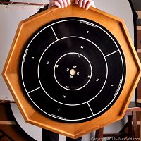 Top view of the wooden octagonal crokinole board with black playing surface showing scoring circles and branding.