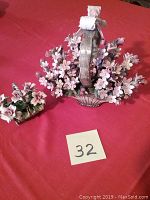 Two porcelain flower basket statues placed side by side on a red fabric background showing overall size and arrangement of flowers with basket handles.