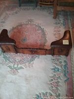 Front view of the antique hearth fender showing wood construction and shape.