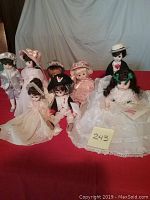 Photo showing all eight Madame Alexander dolls on display with varying outfits and styles.