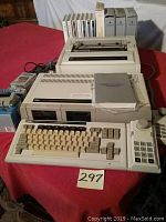 Vintage Coleco Adam computer setup with keyboard, joystick, printer, and software tapes on red table