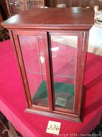 Front and side view of the rectangular display cabinet with glass doors and wood frame.