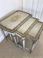 Set of three nested shabby floral accent side tables stacked together showing size progression and nested design.