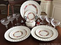 16 piece set displayed on table showing dinnerware, stemware, covered sugar, and salt & pepper shakers