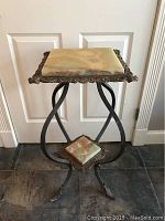 Full view of the vintage two tier plant stand showing square marble top, ornate metal frame and curved legs with claw feet