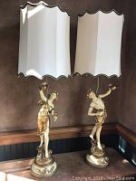 Pair of figural lamps in sunlight showing overall condition and shape with shades attached