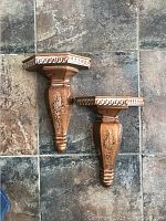 Two brown faux finish wall sconces placed on a tiled floor for visual and condition assessment