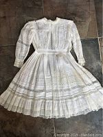 Full view of antique white pintuck and lace girl's dress laid flat, showing detailed sewing and overall condition