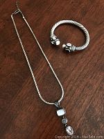 Photo showing the Lori Bonn silver pendant necklace with cabochons along with the Yurman style bangle bracelet on wood surface.
