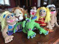 Full view of the six hand puppets: mermaid, lion, green dragon, king, cheerleader, and chef