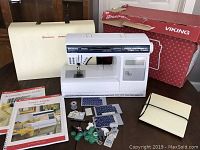 Overview of sewing machine, manuals, bobbins, stitch cards and case